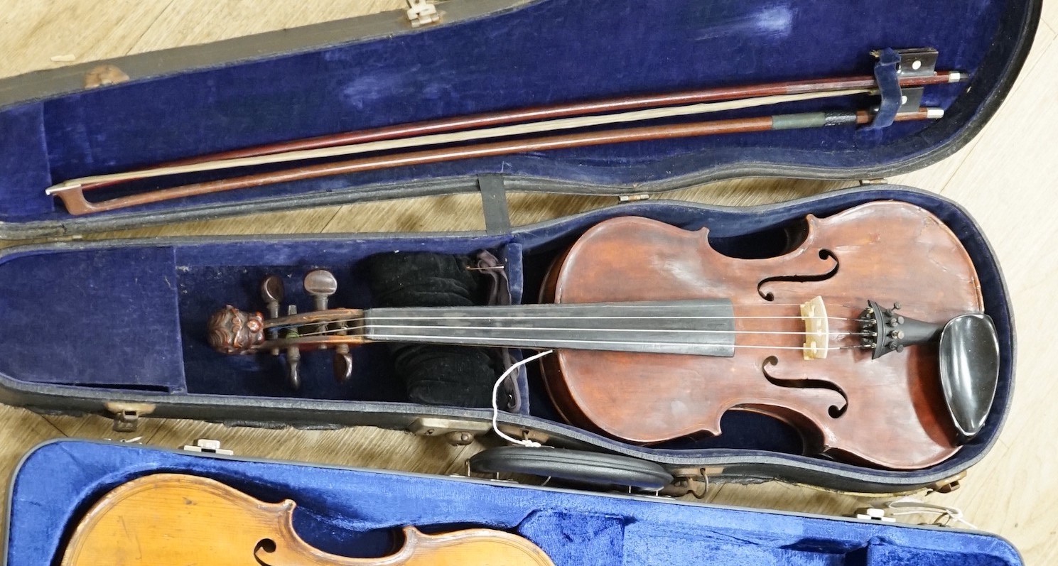 A violin, with carved lion head scroll and two bows in one case